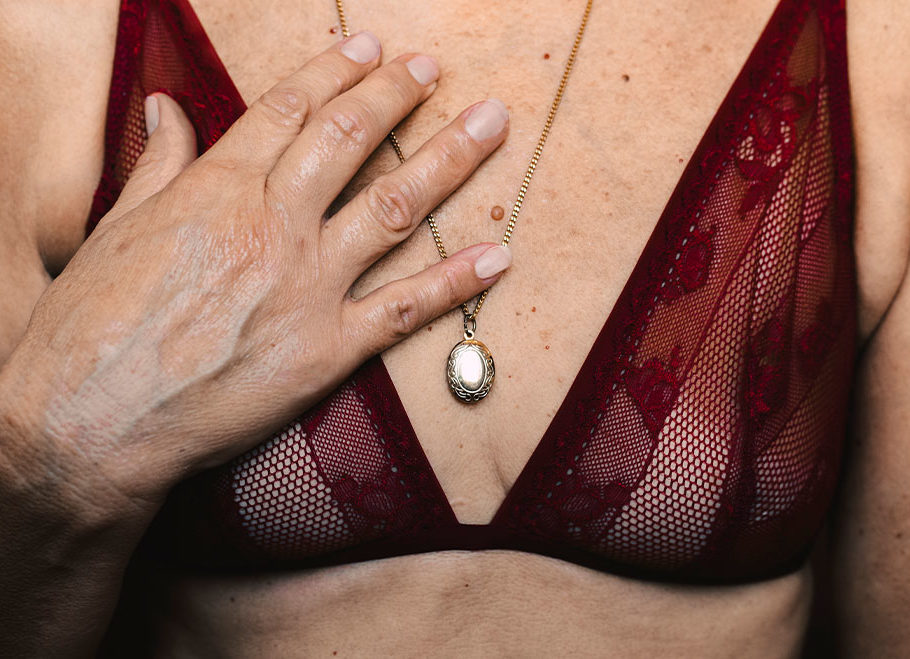 Woman wearing burgundy bran with hand on chest